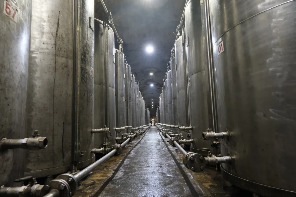 Rows of stainless steel process tanks and pipework in a production facility