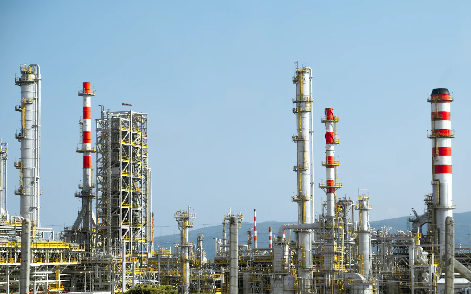 Chemical processing plant – industry reference Industrial processing plant with red and white piping and tall process columns