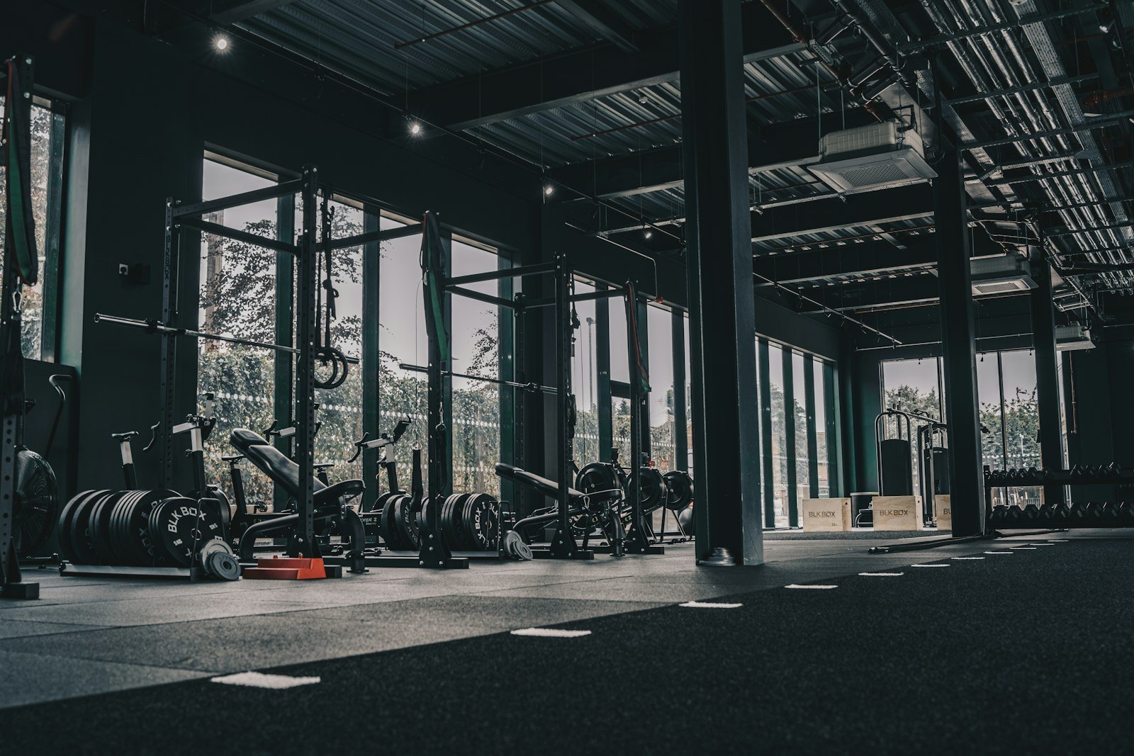 Unoccupied commercial gym with strength training racks, weights and exercise equipment