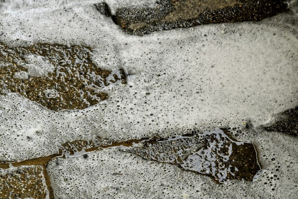 Water and soap patterns on a paved sidewalk, illustrative stock photo